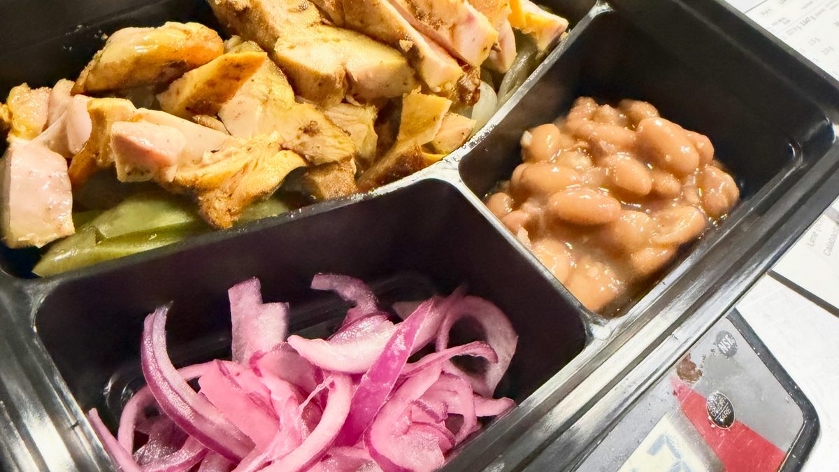 Culinary Curators meal prep box of grilled chicken, beans and pickled onions on a kitchen scale