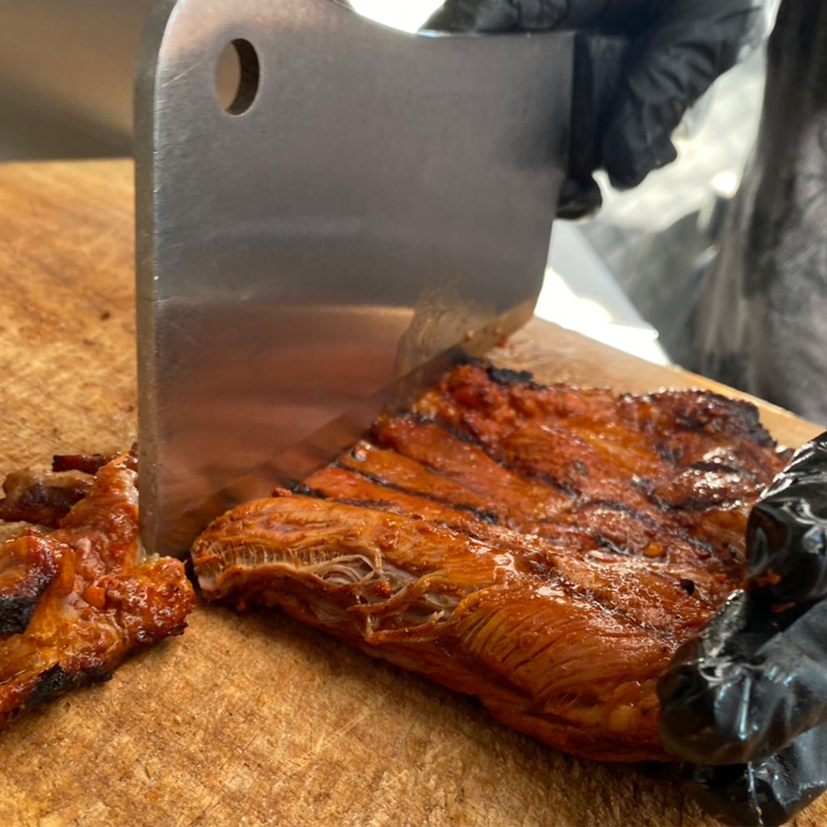 Carving red-oak grilled meat at Tacos El Gringo